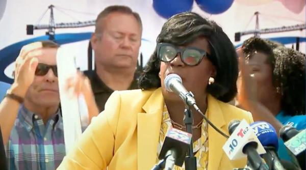 Philadelphia Mayor Cherelle Parker in a yellow jacket speaking into a microphone in support of Vice President Kamala Harris