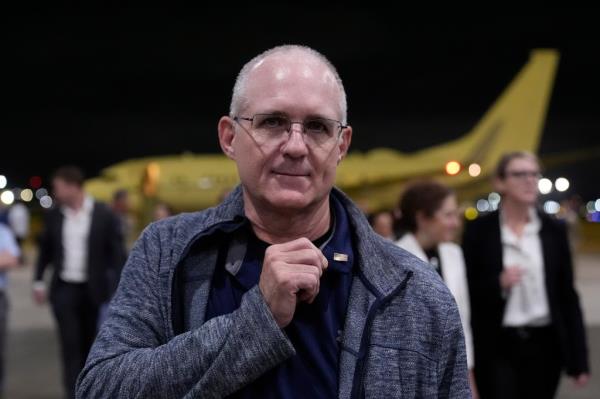 Paul Whelan showing the flag pin he got from President Joe Biden as he arrives at Joint ba<em></em>se San Antonio-Kelly Field.