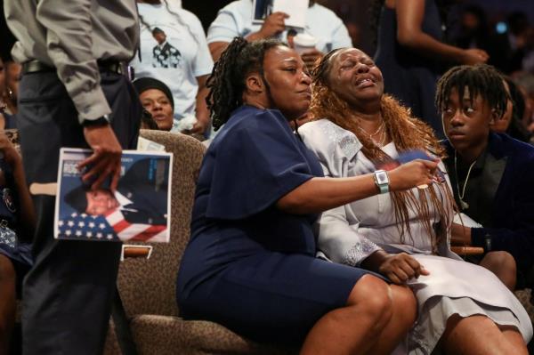 Andre Fortson (right) sat next to his mother during his brother's funeral. 