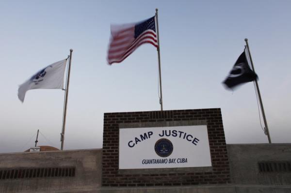 Flags wave above the sign posted at the entrance to Camp Justice, the site of the US war crimes tribunal compound, at Guantanamo Bay US Naval ba<em></em>se, Cuba, May 31, 2009