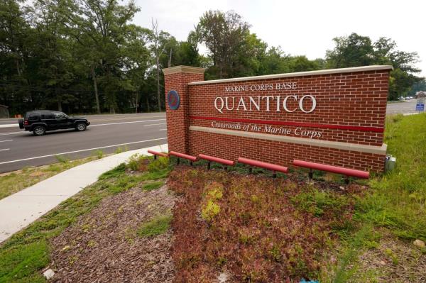 Traffic drives past the entrance sign for Marine Corps ba<em></em>se Quantico.