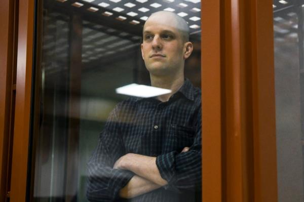 Wall Street Journal reporter Evan Gershkovich stands in a glass cage in a courtroom in Yekaterinburg, Russia