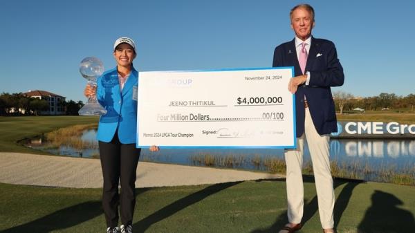 Jeeno Thitikul accepts a winner's cheque of $4m after victory in Florida